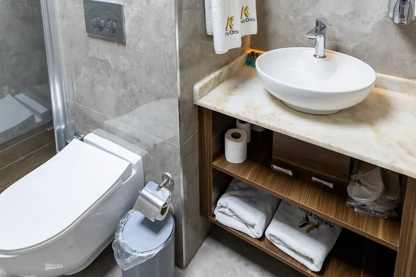 Deluxe Oda banyosunda çanak lavabo ve ahşap rafta katlanmış Aktaş Otel havluları